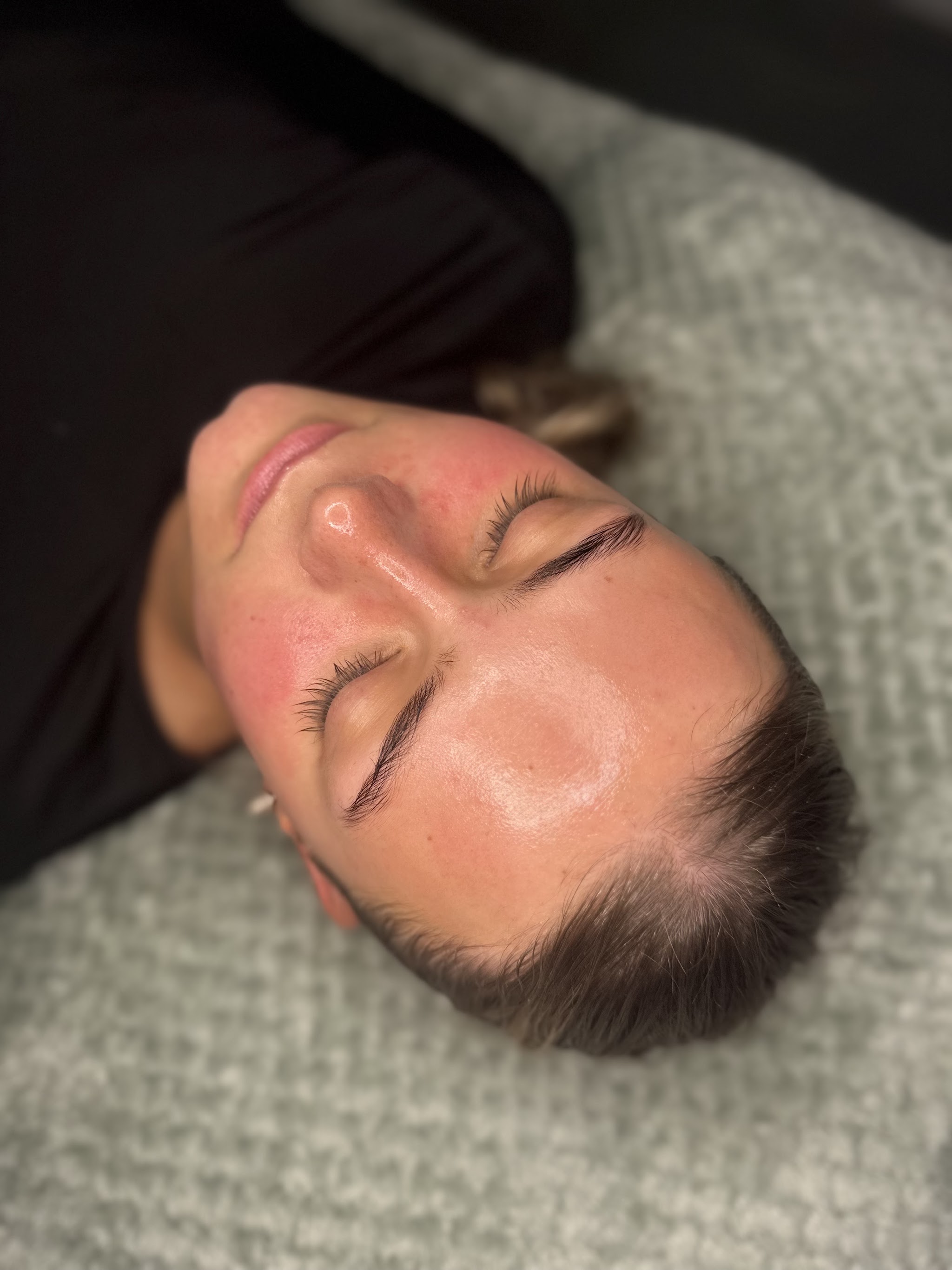 A client resting on a soft blanket after her facial